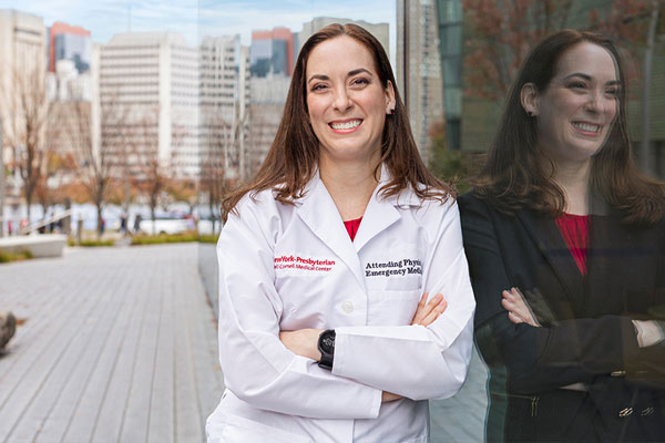 A master’s in healthcare management graduate stands outside Weill Cornell Medicine.